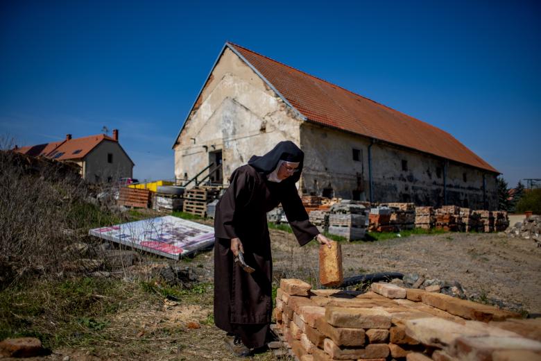 Drasty (Czech Republic), 22/04/2023.- A nun (C) from the Discalced Carmelites order works at the construction site of their new convent in the village of Drasty, Czech Republic, 22 April 2023 (issued 28 April 2023). With their mission to Prague coming to an end, and tired of the capital's nightlife noises, the nuns moved to Drasty in 2018. After learning how to operate tractors and excavators, with the help of the local community, the order is currently building their new convent in the small town north of Prague (República Checa, Praga) EFE/EPA/MARTIN DIVISEK ATTENTION: This Image is part of a PHOTO SET