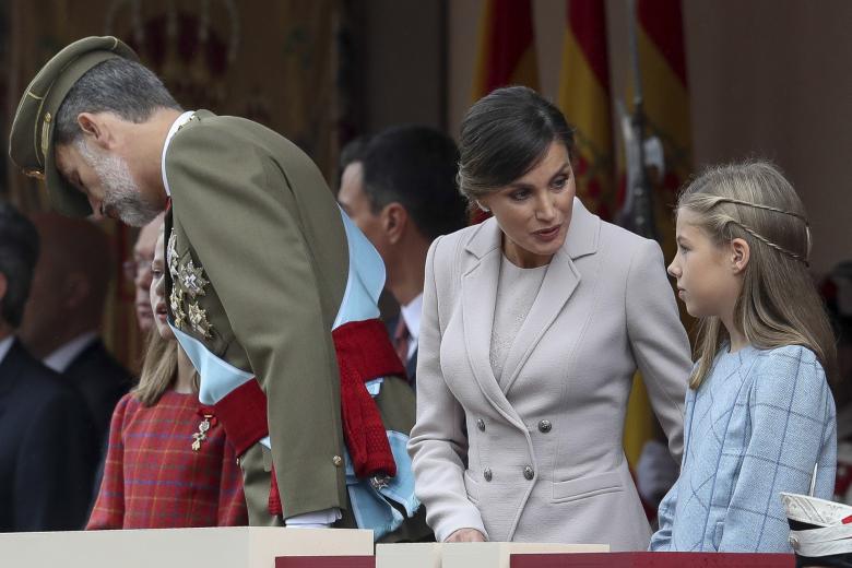 Los reyes Felipe y Letizía están muy pendientes de enseñar el protocolo adecuado para sus hijas en cada ocasión. En este caso, Leonor y Sofía reciben instrucciones durante el desfile del 12 de octubre de 2018