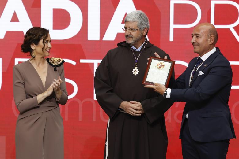 La presidenta de la Comunidad de Madrid, Isabel Díaz Ayuso (i), entrega una Encomienda a Benjamín Echeverría (c), padre superior de la Fraternidad de Jesús de Medinaceli, y a Miguel Ángel Izquierdo, vice hermano mayor de la Archicofradía, en representación de la Basílica de Nuestro Padre Jesús de Medinaceli en Madrid y la Archicofradía Primaria de la Real e Ilustre Esclavitud de Nuestro Padre Nazareno de Medinaceli, durante el acto de entrega de la Medalla de la Comunidad de Madrid y las condecoraciones de la Orden del Dos de Mayo, este martes en la Real Casa de Correos. EFE/ J.J.Guillén