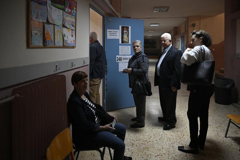 Varios ciudadanos esperan para emitir su voto en un colegio electoral en Atenas