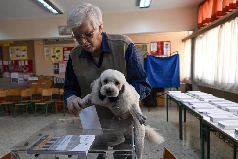 Varios ciudadanos esperan para emitir su voto en un colegio electoral en Atenas