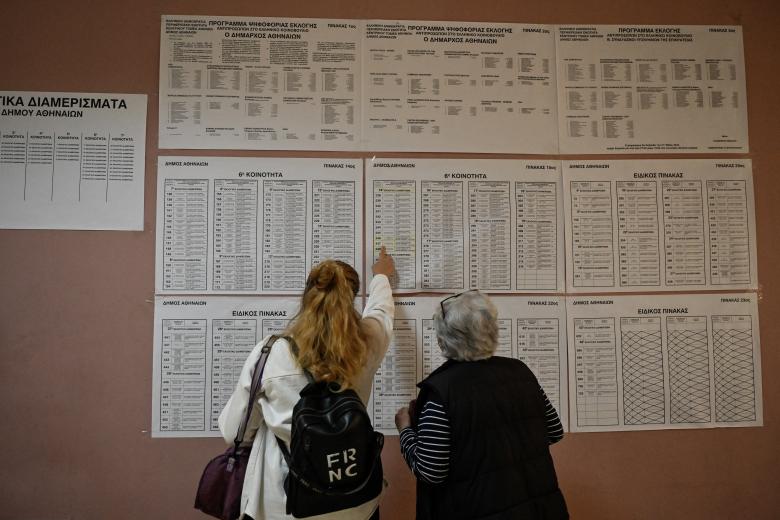 Varios ciudadanos esperan para emitir su voto en un colegio electoral en Atenas