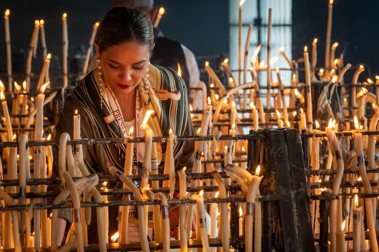 GRAFAND2183. EL ROCÍO (HUELVA), 28/05/2023.- Una mujer enciende una vela este domingo en el velario del Santuario de la Virgen del Rocío de la aldea almonteña de El Rocío (Huelva). EFE/Julián Pérez