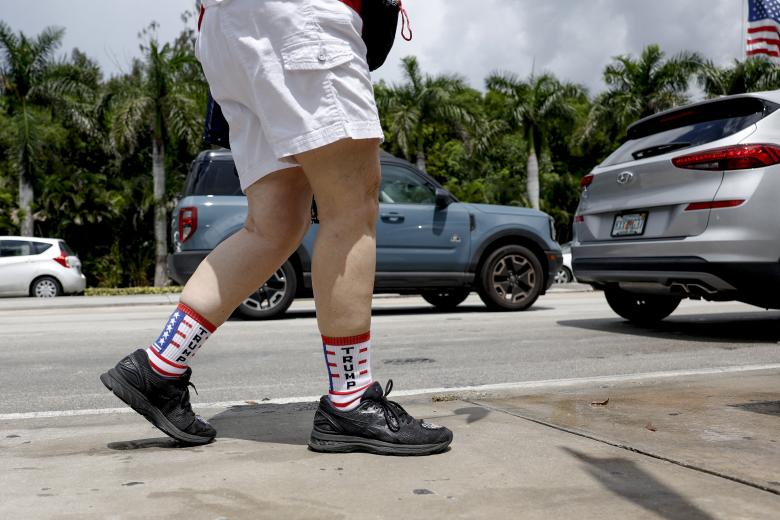 Un partidario del expresidente Donald Trump espera que llegue fuera de una Corte Federal en Miami