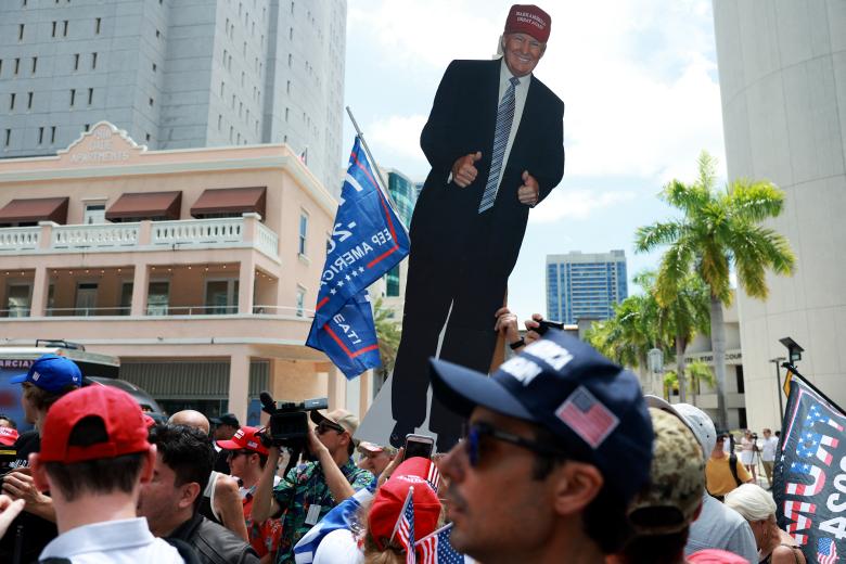 Varias personas sostienen una imagen del expresidente Donald Trump fuera de la Corte