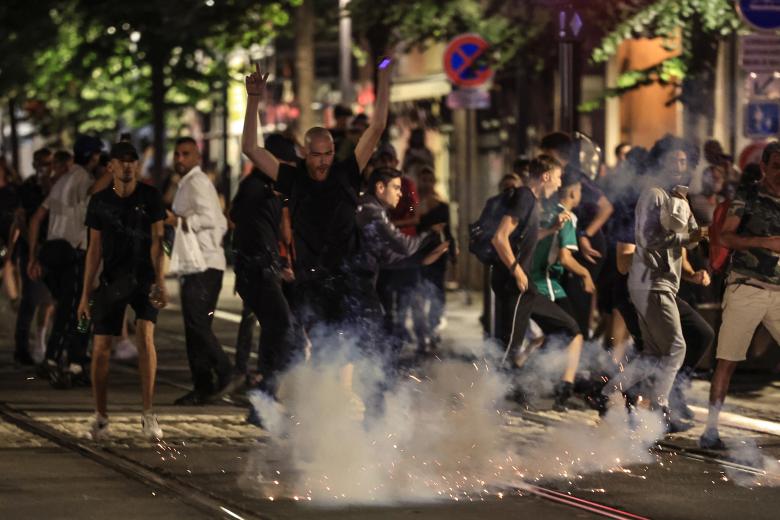 Los manifestantes huyen de una explosión de fuegos artificiales en una calle de Niza, sureste de Francia
