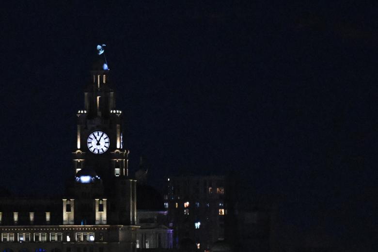 La superluna de julio, se eleva a través de las nubes detrás del Liver Building en Liverpool, noroeste de Inglaterra, a última hora del 3 de julio de 2023. (Foto de Paul ELLIS / AFP)