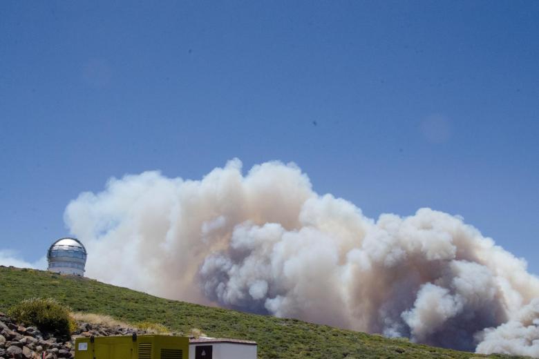 El humo del incendio forestal que comenzó esta madrugada en el municipio palmero de Garafía se observa en varios puntos de la isla, como en el Roque de los Muchachos