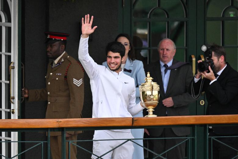 Carlos Alcaraz saluda a los aficionados desde el palco exterior de la pista central del All England Tennis Club
