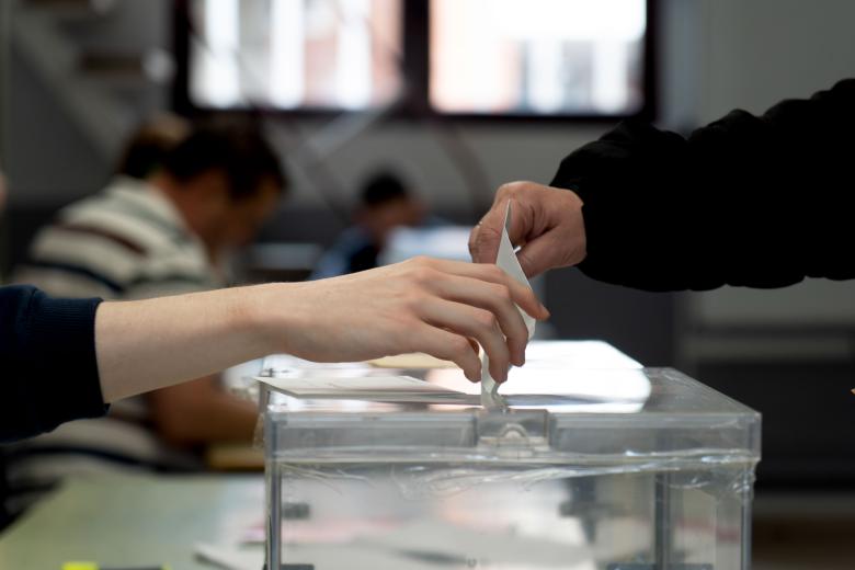 Un votante deposita su papeleta en la urna en un colegio electoral de Teruel