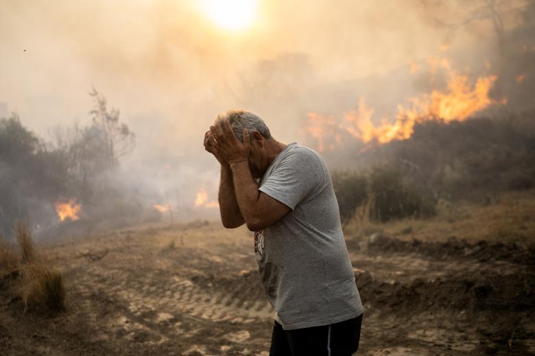 Un hombre reacciona cuando un incendio arde en el pueblo de Gennadi en la isla griega de Rodas