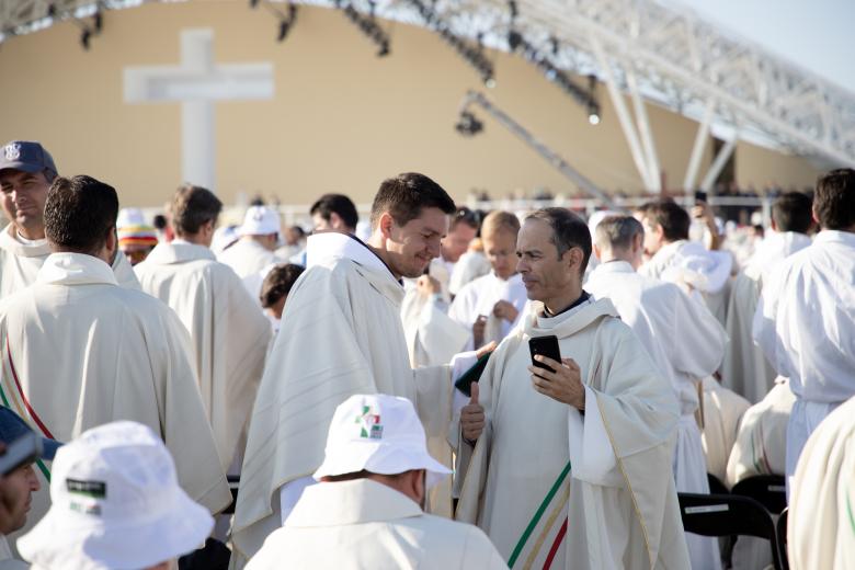 Dos sacerdotes conversan antes de comenzar la Eucaristía