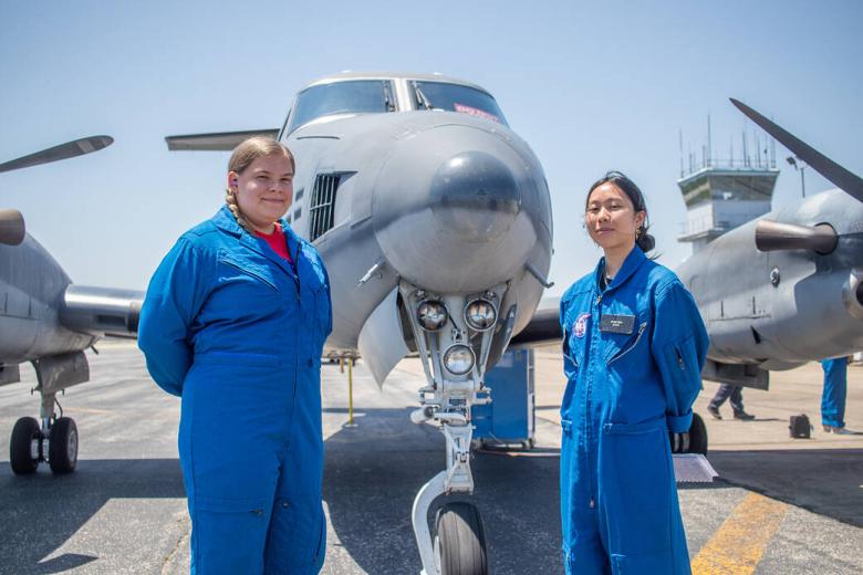 Dorothy Sue Grimmer y Victoria Tran, pasantes del Programa de investigación aerotransportada para estudiantes (SARP) de la NASA, posan para una foto frente al Dynamic Aviation B200 antes de su vuelo de investigación matutino el martes 13 de junio de 2023