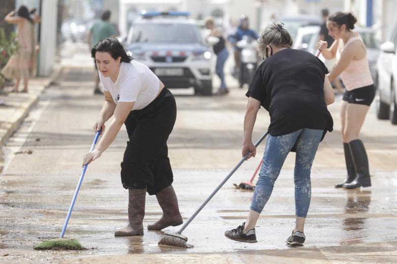 Varias mujeres barren las calles del camping Els Alfacs (Tarragona) tras las intensas lluvias de este domingo