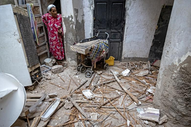 Una mujer observa los desperfectos de una vivienda causados por el terremoto.