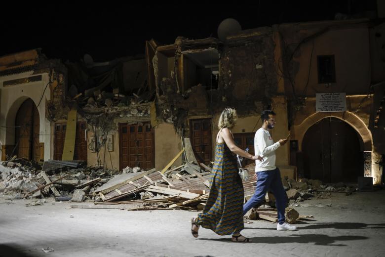 Marrakech (Morocco), 10/09/2023.- People pass by a damaged house in the old town of Marrakech, Morocco, 10 September 2023. A powerful earthquake that hit central Morocco late 08 September, killed 1,037 people and injured more than 1,200 others, the country's Interior Ministry announced on 09 September cited by public television. The earthquake, measuring magnitude 6.8 according to the USGS, damaged buildings from villages and towns in the Atlas Mountains to Marrakesh. (Terremoto/sismo, Marruecos) EFE/EPA/YOAN VALAT