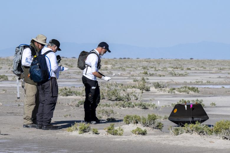 Miembros de la NASA anotan datos de la cápsula minutos después de su aterrizaje