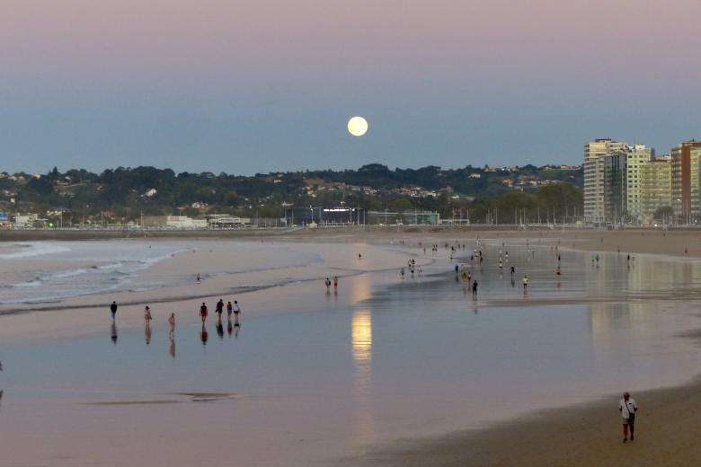 Luna de Cosecha sobre la playa de San Lorenzo, en Gijón (Asturias)