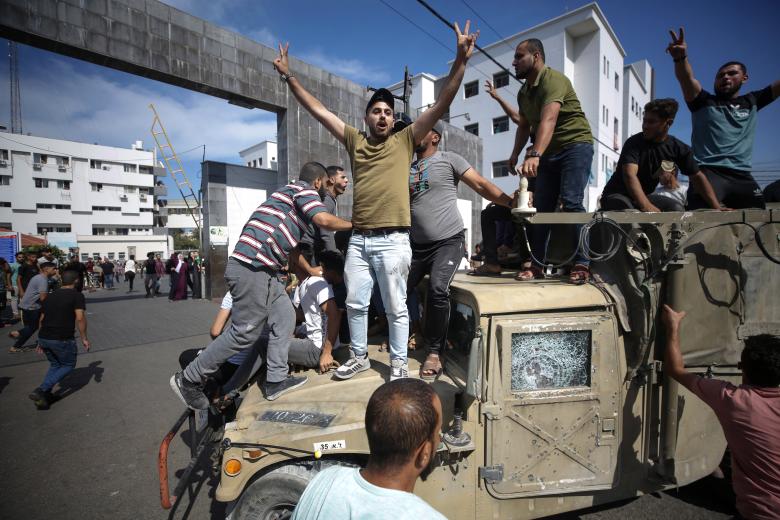 Palestinos sobre un jeep militar israelí por las calles de Gaza.