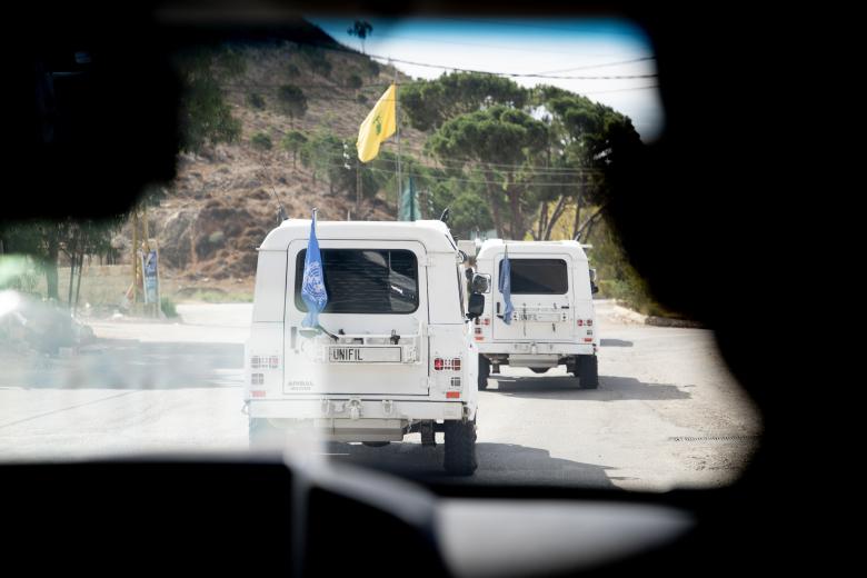 Un vehículo de UNIFIL pasa por delante de una bandera de Hezbolá, el partido y milicia chií libanesa