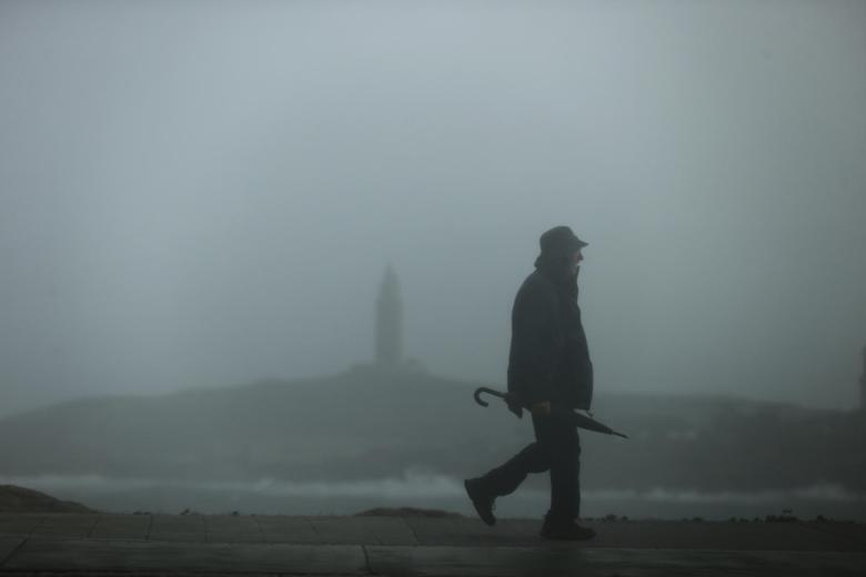 Un hombre camina este jueves por el paseo marítimo de La Coruña, donde el paso de la borrasca Ciarán ha activado la alerta roja en el litoral de La Coruña por olas de hasta 9 metros y vientos superiores a los 100 km/h