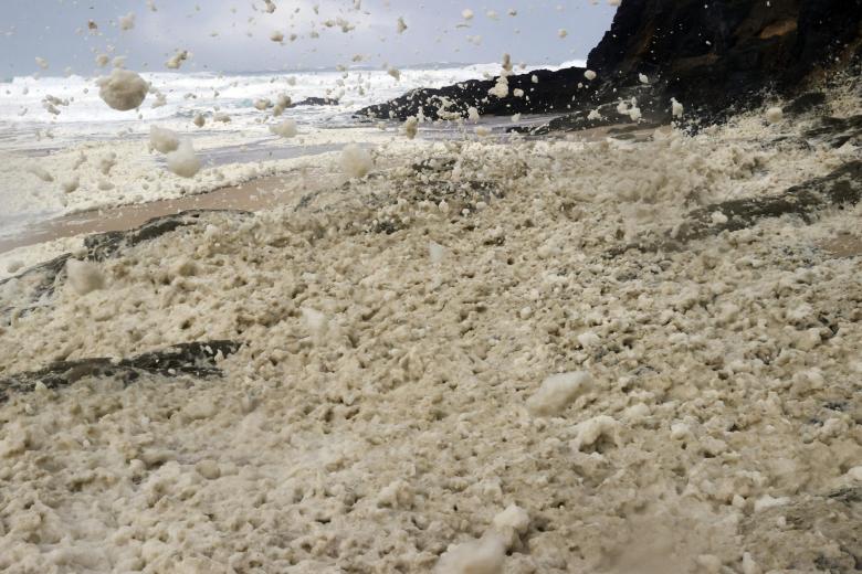 Detalle de la espuma producida por las olas en una playa de la localidad coruñesa de Vadoviño este jueves durante el paso de la borrasca Ciarán
