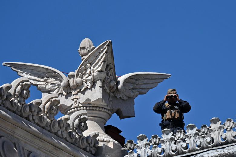 Un oficial de policía vigila desde el techo del Congreso antes de la toma de posesión