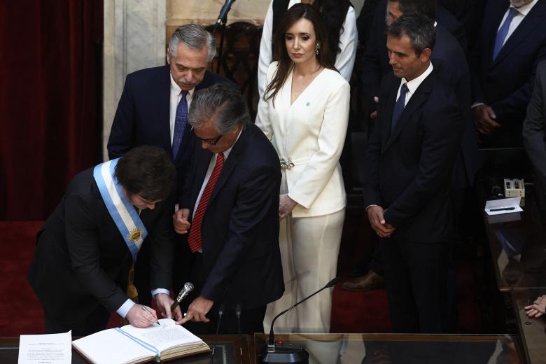 Javier Milei estampa su firma frente al presidente saliente Alberto Fernández y la nueva vicepresidenta Victoria Villarruel