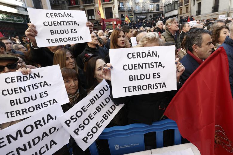 Manifestantes con sus pancartas en al concentración de Pamplona en contra del pacto entre PSOE y Bildu