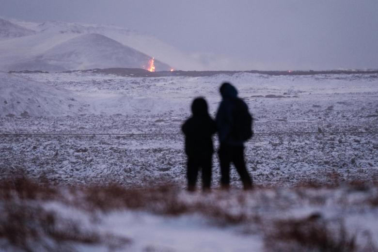 Grindavik (Iceland), 19/12/2023.- Onlookers gather to watch the lava flow after a volcanic eruption near the town of Grindavik, Reykjanes peninsula, Iceland, 19 December 2023. The start of a volcanic eruption was announced by Iceland's Meteorological Office on 18 December night after weeks of intense earthquake activity in the area. (Terremoto/sismo, erupción volcánica, Islandia) EFE/EPA/ANTON BRINK