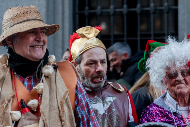 Tres personas disfrazadas guardando cola frente al Teatro Real desde el jueves