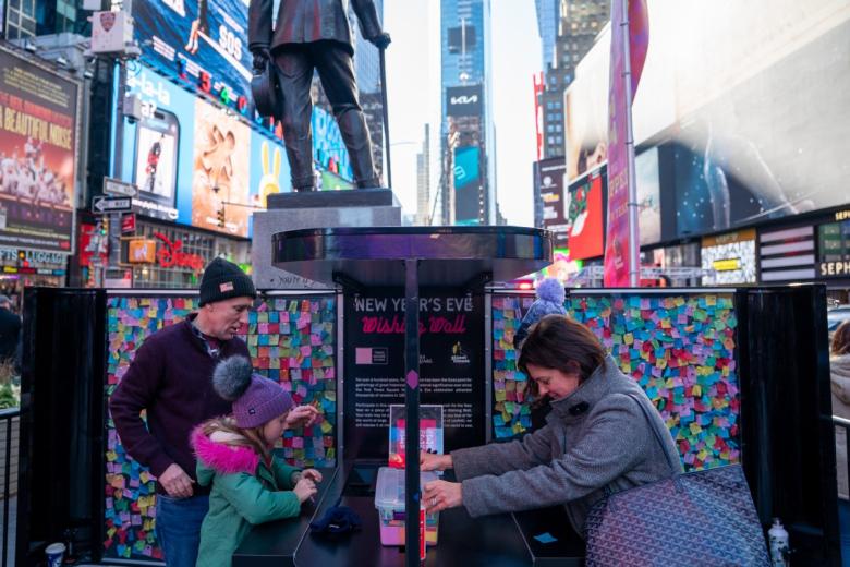 Los visitantes escriben deseos en el Muro de los Deseos de Nochevieja en Times Square. Se utilizarán como parte del confeti para la caída de la bola de Nochevieja.