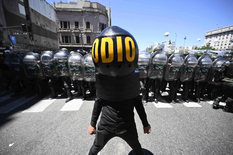 Un hombre representa al presidente Milei con un enorme casco que dice "odio" durante el paro nacional