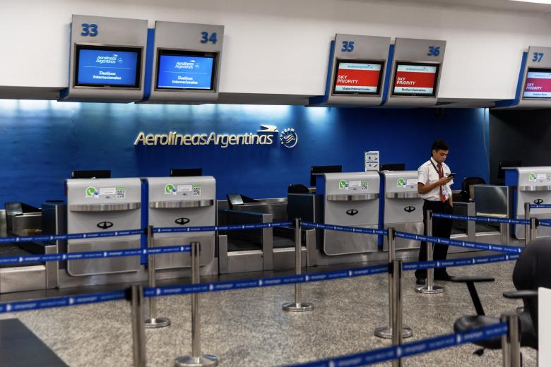 Un empleado del aeropuerto junto a las cabinas de check-in de la estatal Aerolíneas argentinas cerradas por el paro nacional