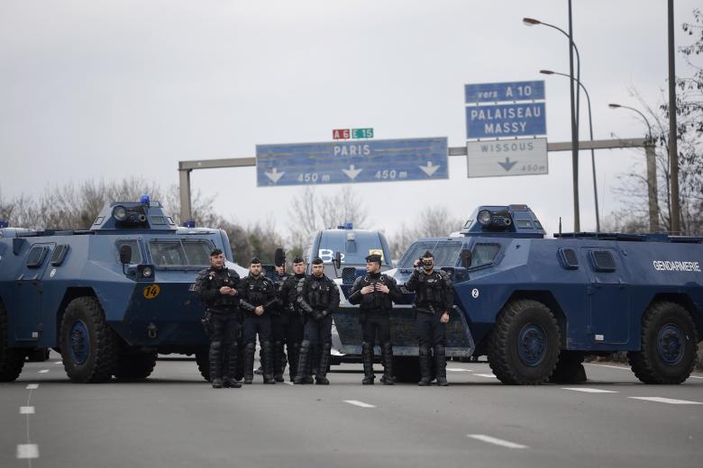 Los vehículos blindados de la policía francesa se encuentran en medio de la autopista mientras decenas de tractores bloquean parte de la autopista A6 en Chilly-Mazarin, al sur de París