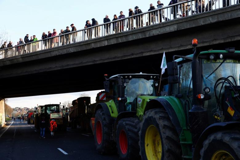 Los vehículos blindados de la policía francesa se encuentran en medio de la autopista mientras decenas de tractores bloquean parte de la autopista A6 en Chilly-Mazarin, al sur de París