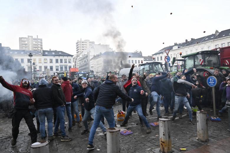 Un manifestante se enfrenta a las fuerzas policiales durante la acción de protesta de los agricultores en el distrito europeo de Bruselas