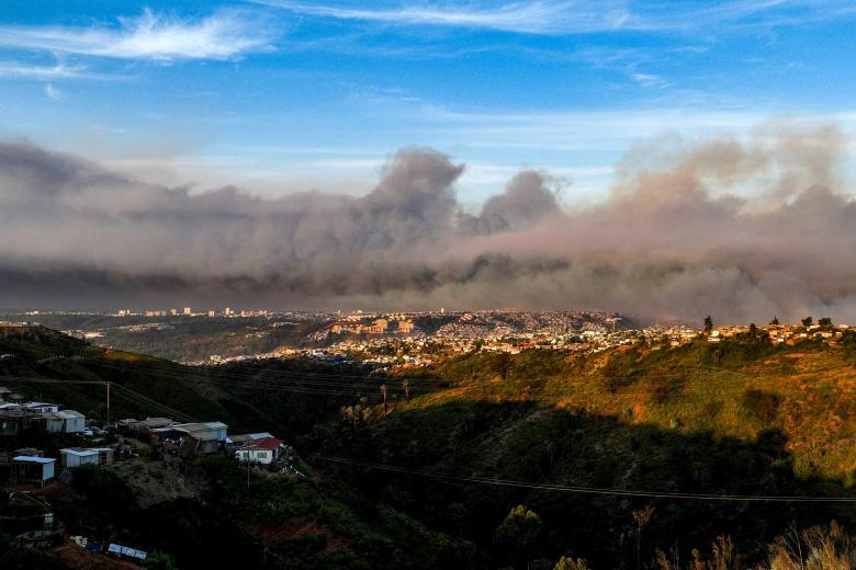 View of the smoke cloud produced by the forest fires in Viña del Mar, taken on February 2, 2024. A huge mushroom cloud of smoke hangs over tourist areas in central Chile, including Viña del Mar and Valparaiso, where a forest fire broke out on Friday, threatening hundreds of homes and forcing the evacuation of residents. (Photo by Javier TORRES / AFP)