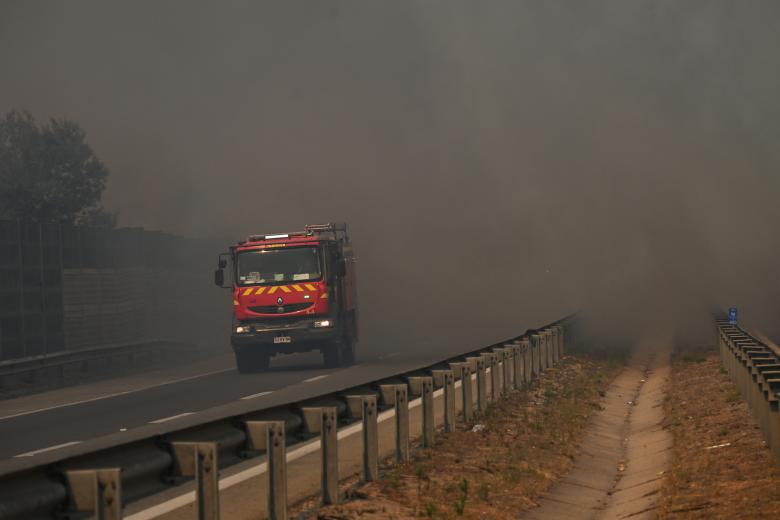 A fire truck is pictured during a forest fire that affected the hills in Quilpe, Viña del Mar, Chile, on February 3, 2024. The region of Valparaoso and Viña del Mar, in central Chile, woke up on Saturday with a partial curfew to allow the movement of evacuees and the transfer of emergency equipment in the midst of a series of unprecedented fires, authorities reported. (Photo by RODRIGO ARANGUA / AFP)