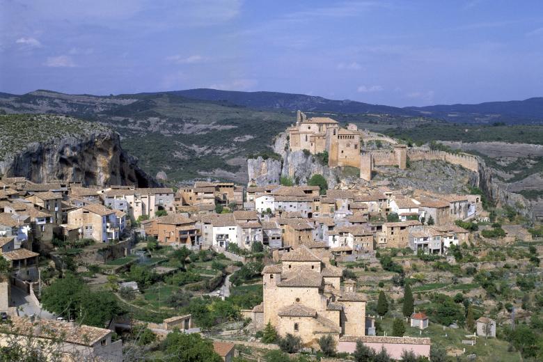 Alquézar, Huesca: Este pueblo forma parte de uno de los pueblos más bellos de España desde 2015, cuando fue acreditada por la asociación Los Pueblos Más Bonitos de España. Si visitas alguna vez Alquézar, no tendrás que buscar para ver porque es considerado uno de los pueblos más bellos. En lo más alto de la villa se encuentra el Mirador La Sonrisa del Viento, desde allí puedes ver todo el pueblo y confirmar porque es tan especial. También tendrás una asombrosa vista al cañón del río Vero. Este pueblo medieval te llevará siglos atrás con sus calles estrechas y empedradas que van a juego con la piedra caliza que recubre todo el lugar.  Entre los principales monumentos de este pueblo que puedes visitar se encuentra un castillo de origen islámico, que tras la reconquista se convirtió en Colegiata. También puedes visitar los restos de la muralla construida en el siglo XI, la torre albarrana, las ruinas de la torre cuadrangular y los restos de la iglesia románica que se encuentran incrustados en las ruinas de un claustro del siglo XVI.