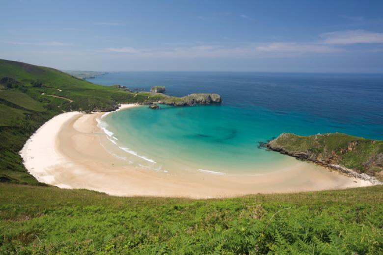 Playa de Torimbia, Asturias. Esta playa ubicada en la localidad asturiana de Niembro en Llanes, es considerada paisaje protegido desde el punto de vista medioambiental por su vegetación. Es considerada como uno de los mejores arenales naturistas. Para acceder a esta playa, hay que atravesar Niembro y hacer los últimos dos kilómetros del trayecto a través de un estrecho camino de arena. Además, cuando la marea está baja desde Torimbia se puede acceder a otras playas, como la de Portacos y Peñadrada. Asimismo, la anchura de Torimbia varía dependiendo de la marea, por lo que oscila entre los 76 y 100 metros. Torimbia, es una playa de concha encajada, y es este aislamiento natural lo que la hace perfecta para el nudismo. Muchos aficionados utilizan esta playa para esta práctica. La profundidad de la zona de baño es bastante baja, no excede el metro y medio, además de esto, la corriente es escasa, por lo que no es una playa peligrosa.