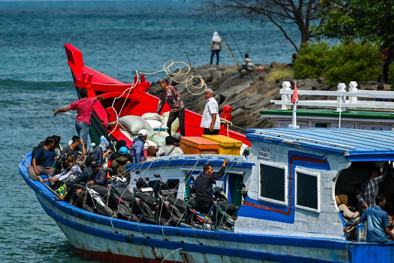 Dos barcos cargados con material electoral y motocicletas se preparan para zarpar hacia islas remotas de Indonesia