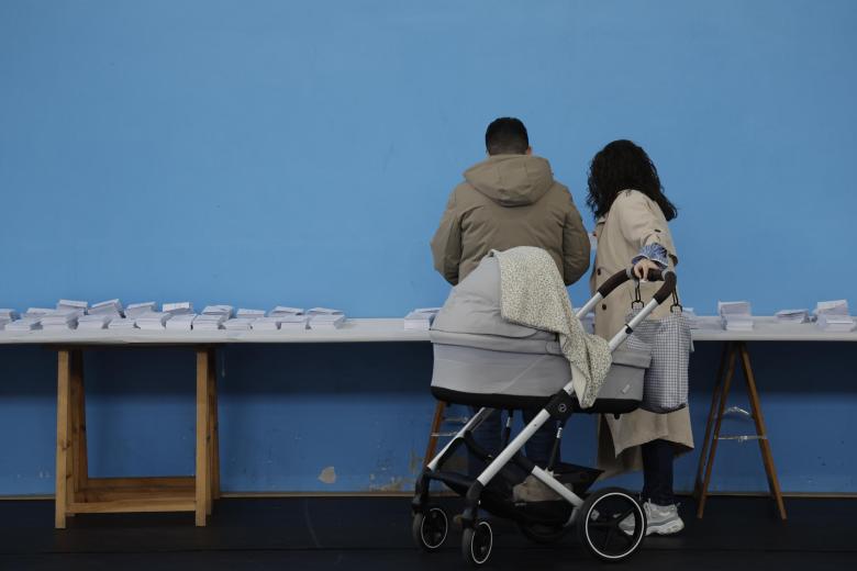 SANTIAGO DE COMPOSTELA, 18/02/2024.- Una pareja escoge una papeleta para ejercer su derecho al voto en el colegio Ames a las afueras de Santiago de Compostela al comienzo dedurante la jornada electoral en Galicia, este domingo. Los colegios electorales de Galicia han abierto sus puertas a las 09:00 horas de este domingo para empezar a recibir a los más de 2,2 millones de gallegos que están llamados a votar antes de que den las 20:00 horas. EFE/ Lavandeira Jr