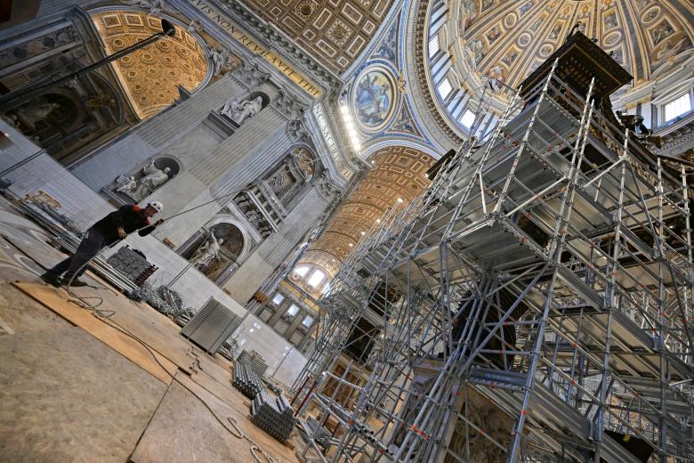 Workers mount a scaffolding around the baldachin of St. Peter's basilica to start its restoration on February 21, 2024 in the Vatican. The large Baroque sculpted bronze canopy over the high altar of St. Peter's Basilica by artist Gian Lorenzo Bernini dated from 1634. (Photo by Andreas SOLARO / AFP)
