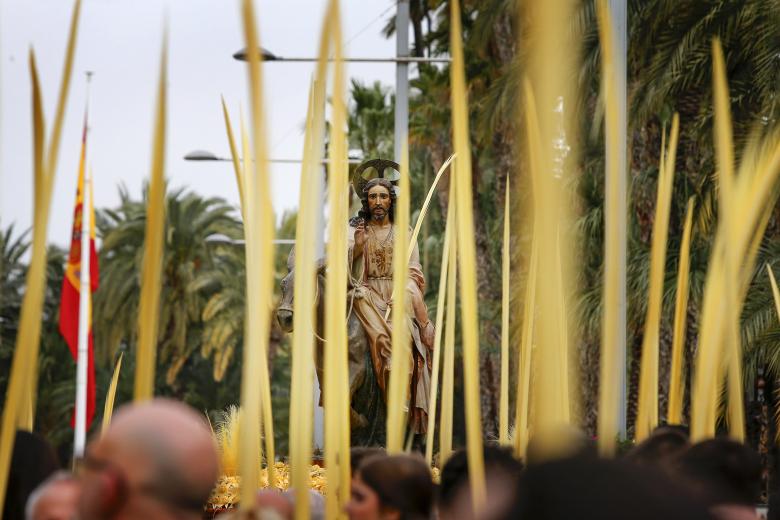 Miles de personas con la tradicional palma blanca participan en la procesión del Domingo de Ramos de Elche, declarada de interés turístico internacional en 1997.