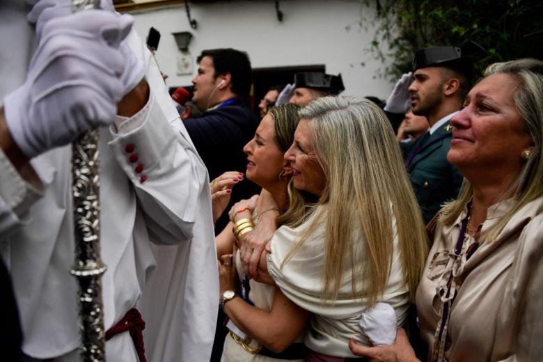 La emoción de los sevillanos ante los penitentes de la hermandad de La Paz en el Domingo de Ramos en Sevilla.