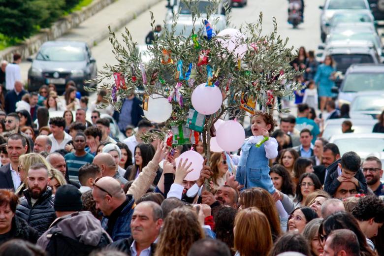 La gente lleva una rama de olivo mientras participa en la procesión del Domingo de Ramos en la aldea de Qlayaa en el sur del Líbano, cerca de la frontera con Israel.