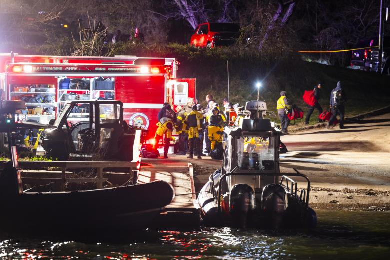 El personal de rescate se reúne en la orilla del río Patapsco después de que un buque de carga chocara contra el puente Francis Scott Key provocando su colapso, en Baltimore, Maryland, EE.UU