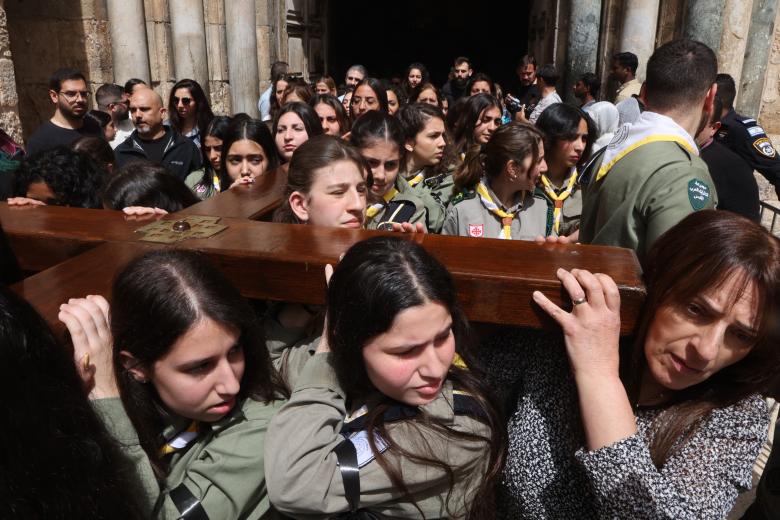 Los fieles llevan una cruz de madera al salir de la iglesia del Santo Sepulcro durante la procesión del Viernes Santo por la Vía Dolorosa en la Ciudad Vieja de Jerusalén
