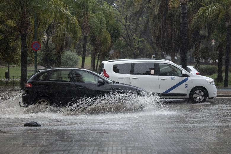 Varios coches circulan bajo la lluvia que estaba cayendo en Sevilla este sábado como consecuencia de la borrasca Nelson.